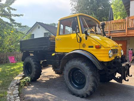UNIMOG 406 zweiachsige Zugmaschine mit geschlossenem F�hrerhaus, beschr�nkte Lasdefl�che mit umlegbaren Bordw�nden, 1 Lenkersitz, 1 Mitfahrersitz, fallweise mit Aufsteckbordw�nden als Sitzb�nke f�r 6 Personen verwendbar, Diesel-Viertaktmotor, Gesamthubrau